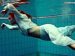 Elegant redhead goes swimming in her sexy clothes